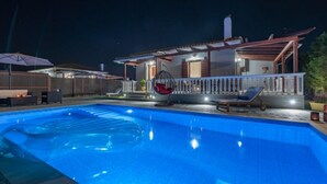 A swimming pool with a wooden deck and lounge chairs. - Villa Rose With Private Pool (Zakynthos)