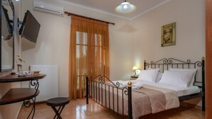 A bedroom with a bed, a desk, a chair, a window with curtains, and a painting on the wall. - Villa Rose With Private Pool (Zakynthos)