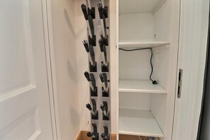 A kitchen with a utensil holder on the wall and a power outlet on the countertop.