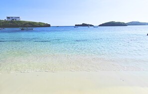 Una playa cerca, sillas reclinables de playa, sombrillas