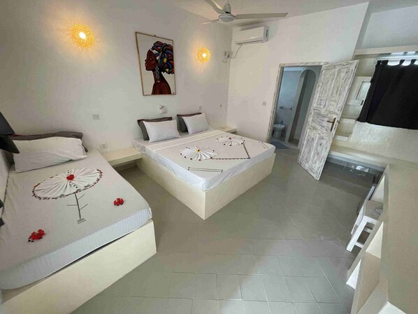 A hotel room with two beds, a ceiling fan, an air conditioning unit, and a painting on the wall.