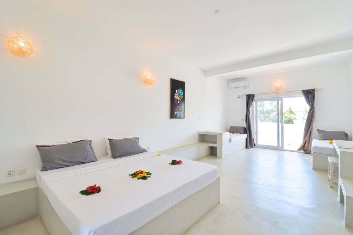 Ein modernes Hotelzimmer mit einem großen Bett, einem Schreibtisch und einem Balkon.