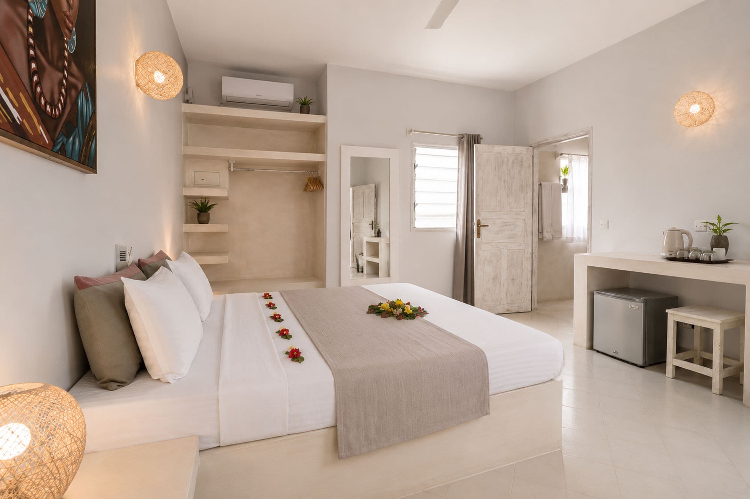 A modern bedroom with a large bed, bedside tables, a desk, and a walk-in closet.