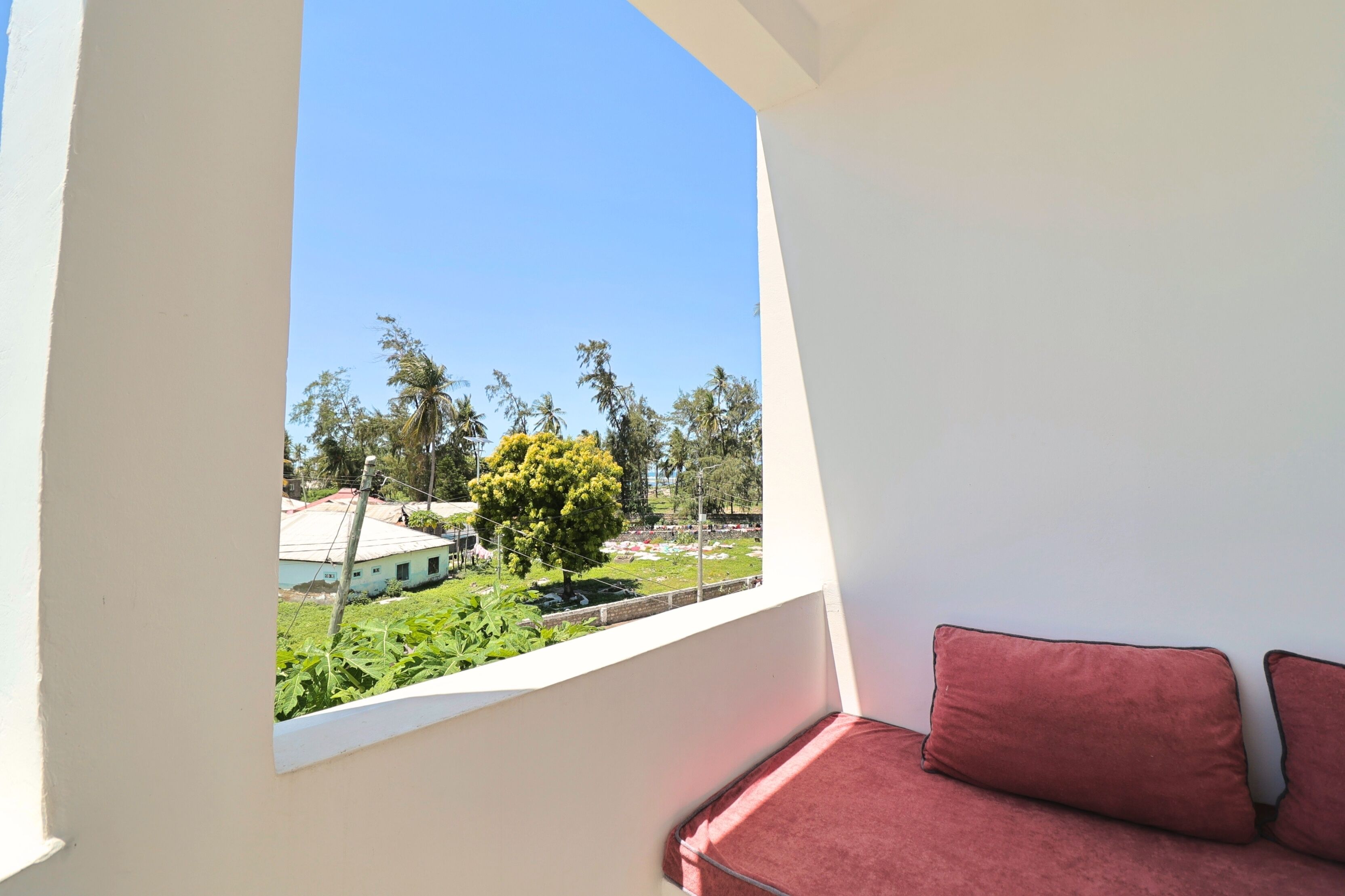 A balcony with a view of a garden and a building.