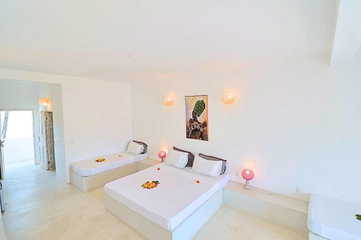 Ein Hotelzimmer mit zwei Betten, einem Bild an der Wand und zwei Wandleuchten.