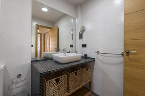 Une salle de bain avec deux lavabos, un miroir et un porte-serviettes.