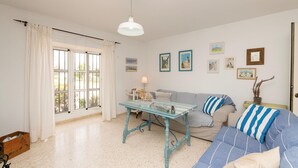 A living room with a glass coffee table, striped sofas, and a large window with curtains. - El Coto in Chiclana de la Frontera (Chiclana de la Frontera)