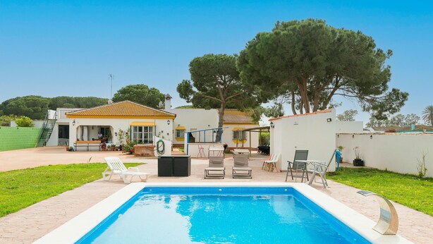 A swimming pool with lounge chairs and a patio area. - El Coto in Chiclana de la Frontera (Chiclana de la Frontera)