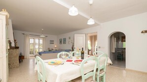 A dining area with a table set for four, chairs, and a kitchen in the background. - El Coto in Chiclana de la Frontera (Chiclana de la Frontera)