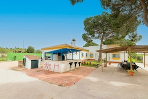 A patio area with a small kiosk, outdoor seating, and a pergola. - El Coto in Chiclana de la Frontera (Chiclana de la Frontera)