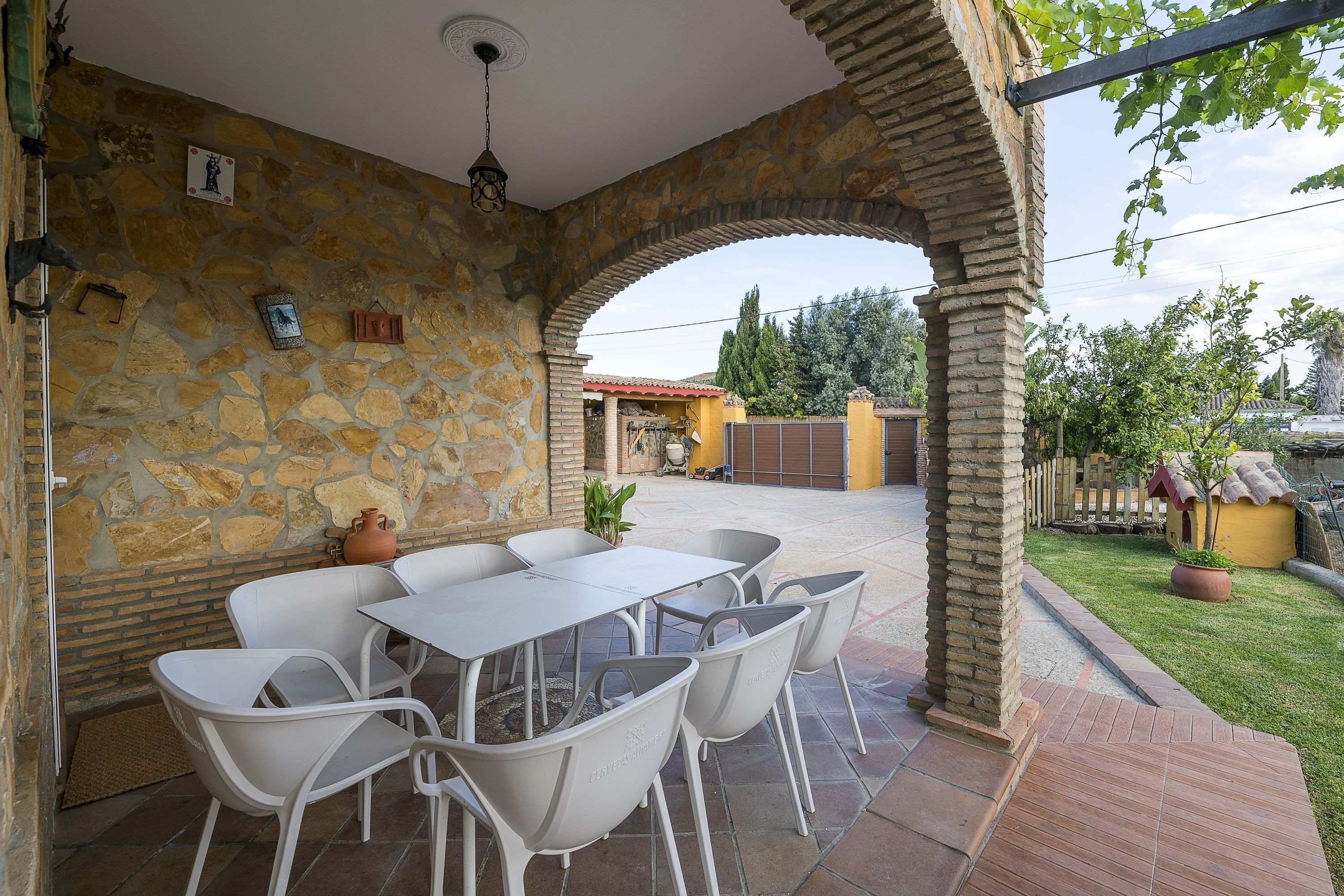 Eine Terrasse im Freien mit Steinmauern, einem Tisch und Stühlen.
