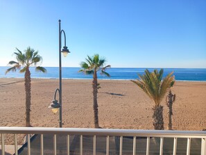 A beach with palm trees and a street lamp.