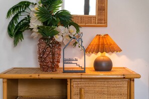 A wooden console table with a decorative vase, a framed sign, and a lamp.