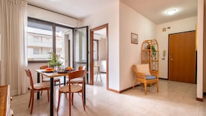 A dining area with a table, chairs, and a potted plant. - Sardinia RE - Lilium Central Flat (Alghero)