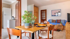A compact living space with a dining area, kitchenette, and a sofa set. - Sardinia RE - Lilium Central Flat (Alghero)