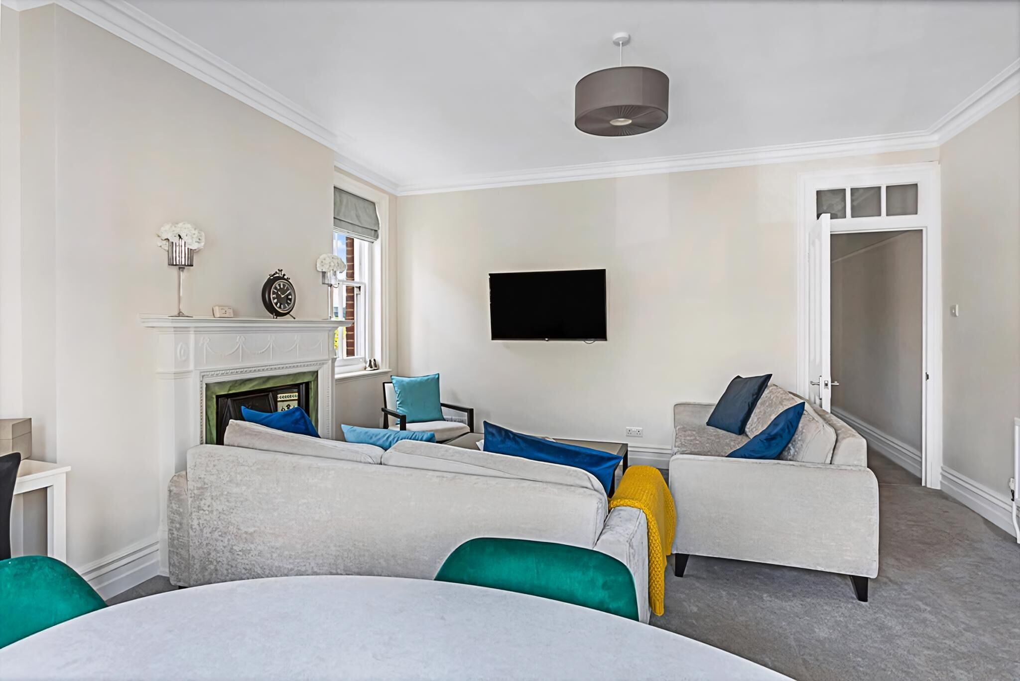 Een moderne woonkamer met een open haard, een flatscreen televisie en een zithoek.