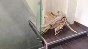 Eine Treppe mit Glastrennwand und einem Stück Treibholz auf der Zwischenebene.