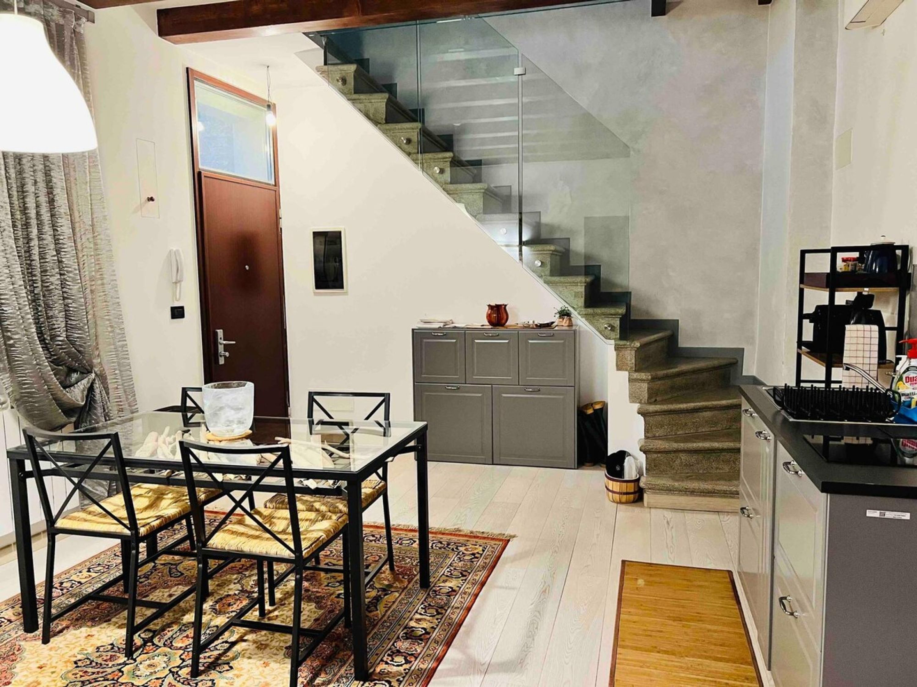 A modern kitchen with a built-in stove, grey cabinets, and a small countertop.