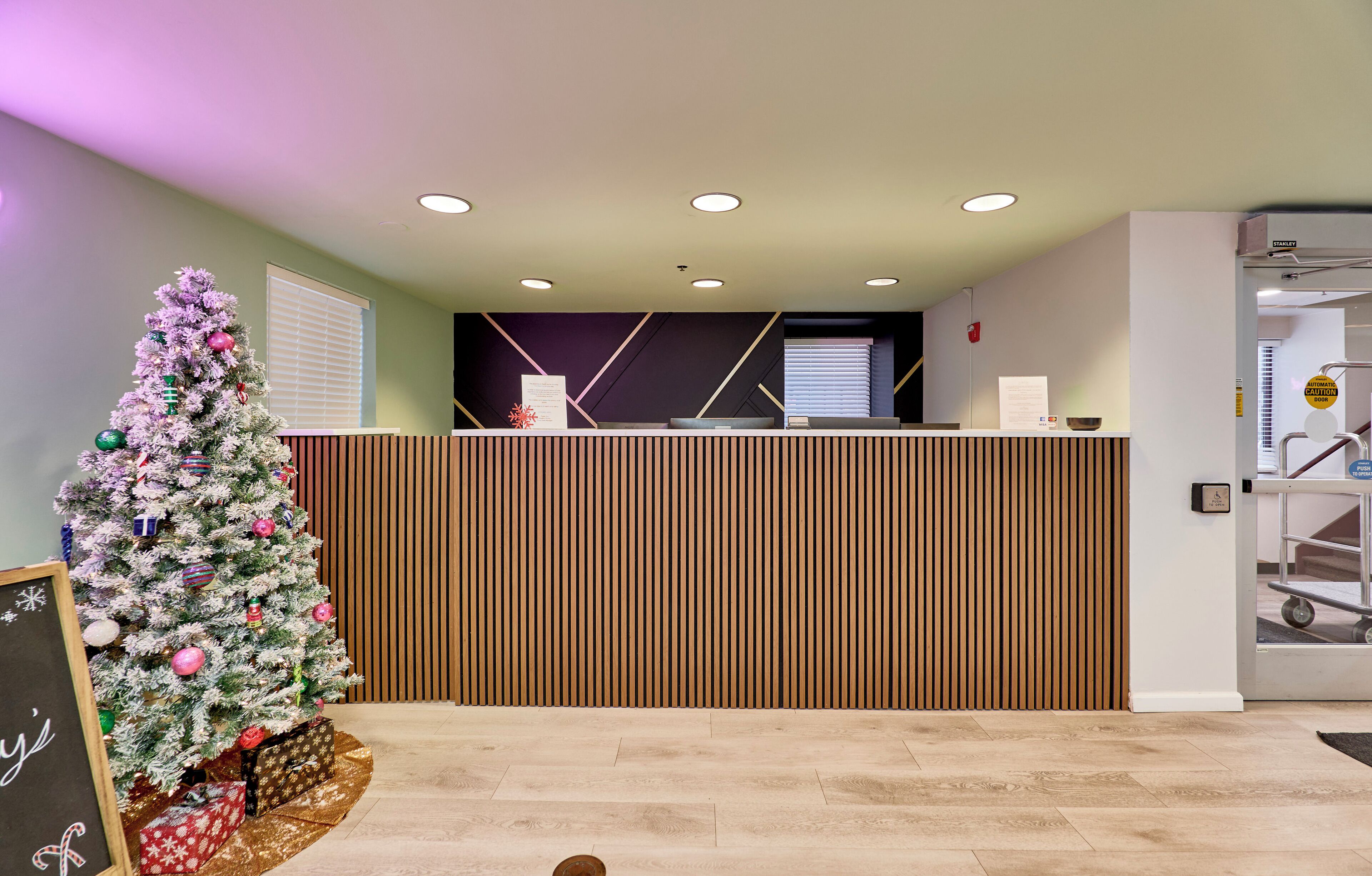 A reception area with a Christmas tree, a reception desk, and a sign indicating a smoking area.