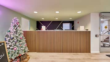 A reception area with a Christmas tree, a reception desk, and a sign indicating a smoking area.