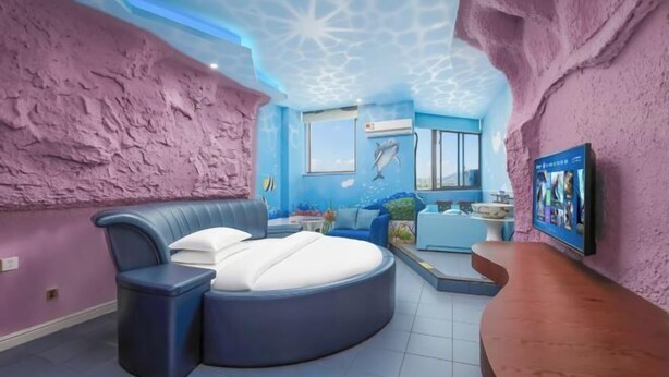 A room with a round bed, a small seating area, a TV, and a window with a view. - Changsha Xingangwan Hotel (Changsha)