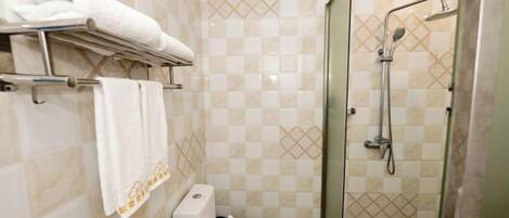 Ein Badezimmer mit Toilette, Dusche und Handtuchhalter.