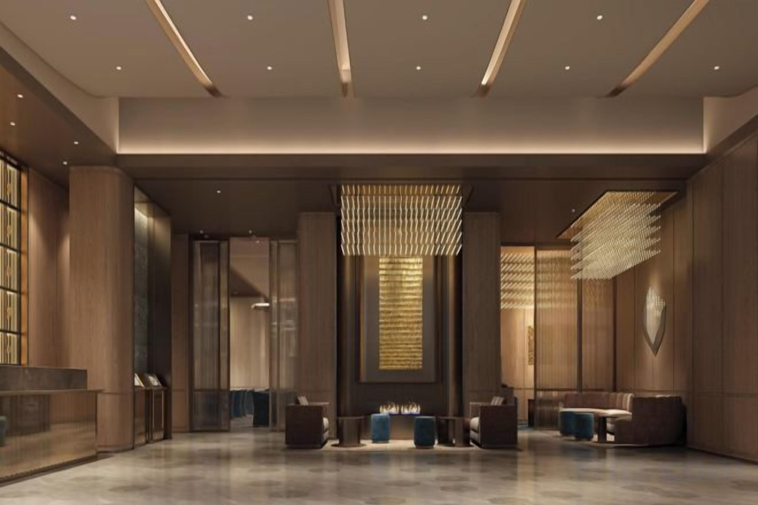 A spacious lobby with a reception desk, seating area, and a decorative light fixture.