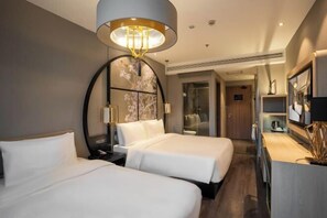 A hotel room with two beds, a large mirror, a modern chandelier, and a television. - Crystal Orange (Shanghai Oriental Pearl Binjiang) (Shanghai)