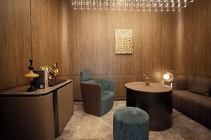 A room with a wooden panel wall, a round table, a sofa, a chair, and a small ottoman. - Crystal Orange (Shanghai Oriental Pearl Binjiang) (Shanghai)