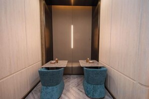 A narrow hallway with two tables and chairs, a vertical light fixture, and a door at the end. - Crystal Orange (Shanghai Oriental Pearl Binjiang) (Shanghai)