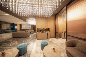 A modern lobby with seating areas, a reception desk, and a decorative ceiling light fixture. - Crystal Orange (Shanghai Oriental Pearl Binjiang) (Shanghai)