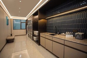 A modern kitchen with a built-in washer and dryer, a sink, and a countertop with various items. - Crystal Orange (Shanghai Oriental Pearl Binjiang) (Shanghai)