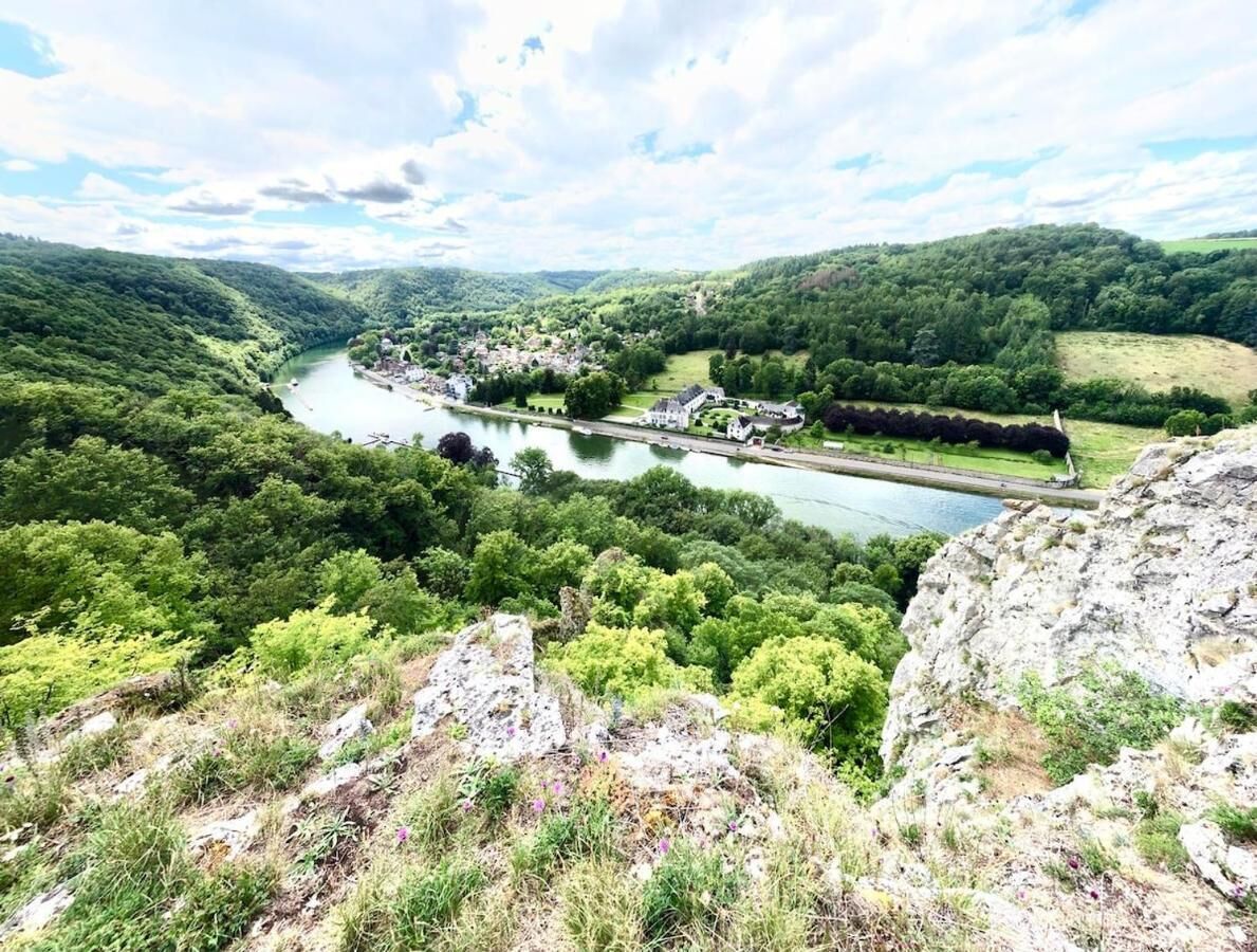 Une rivière traverse une vallée où se trouve une petite ville, et des bâtiments bordent ses rives.