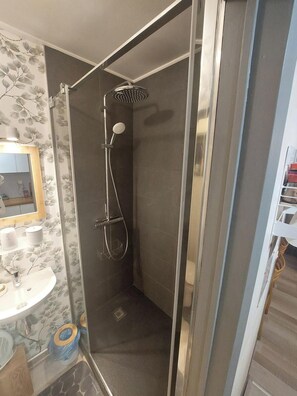 Een douche, een haardroger, handdoeken, toiletpapier