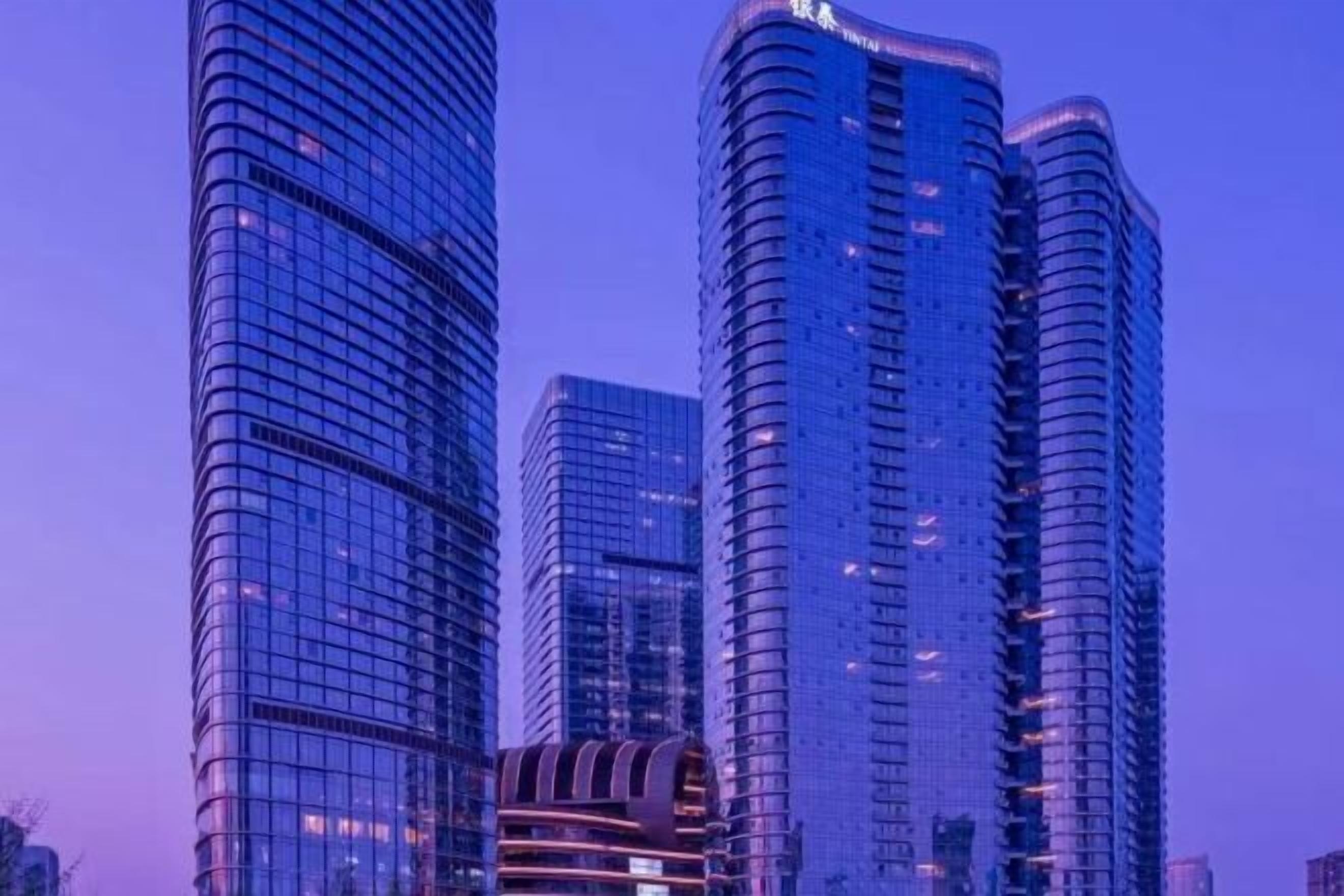 A high-rise building with a curved facade and reflective glass windows.