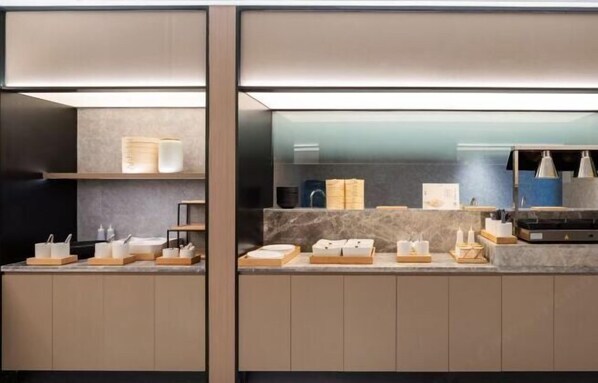 Una habitación de hotel moderna con una encimera de mármol, artículos de aseo ordenados y un separador de vidrio.