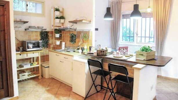 A compact kitchen with a microwave, sink, and a small dining area with two chairs.