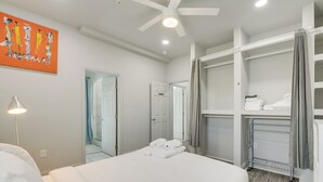 Ein Hotelzimmer mit einem großen Bett, einem begehbaren Kleiderschrank und einem Deckenventilator.