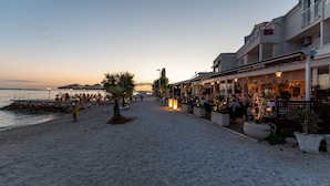 A beachside restaurant with outdoor seating, a pebble path, and a view of the sea. - Luxury Villa David 2 heated pool 38m2 bbq Seaview (Podstrana)