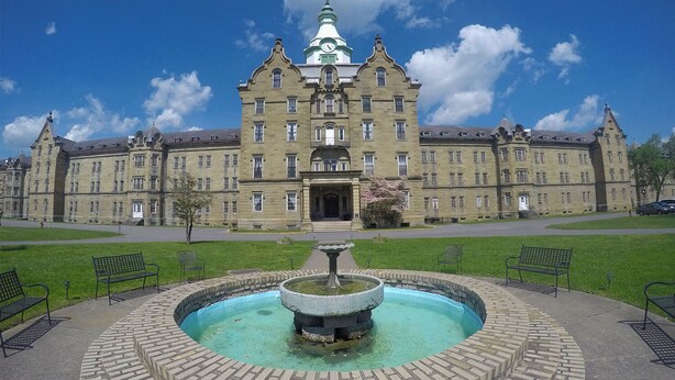 A large, historic building with a central fountain, surrounded by a brick pathway and benches. - Spacious family friendly 4-BR property with AC, Fireplace and WiFi in Sutton, WV (Sutton)
