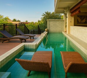 A swimming pool with lounge chairs and a tiled deck. - Anaya Hotel Canggu (Pererenan)