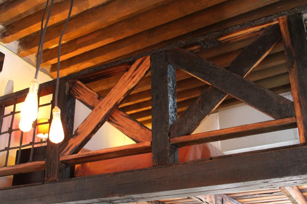 A wooden ceiling structure with exposed beams and hanging light bulbs.
