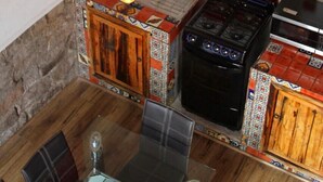 A kitchen with wooden cabinets, a stove, and hanging light bulbs.