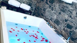 A bathtub filled with water and rose petals, with a champagne bottle and glasses. - B&B Il Salento di Fioravante (Minervino di Lecce)