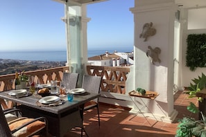 A terrace with a table set for dining, overlooking a coastal view. - Pool Apt Calahonda 2 With Sea View (Mijas)