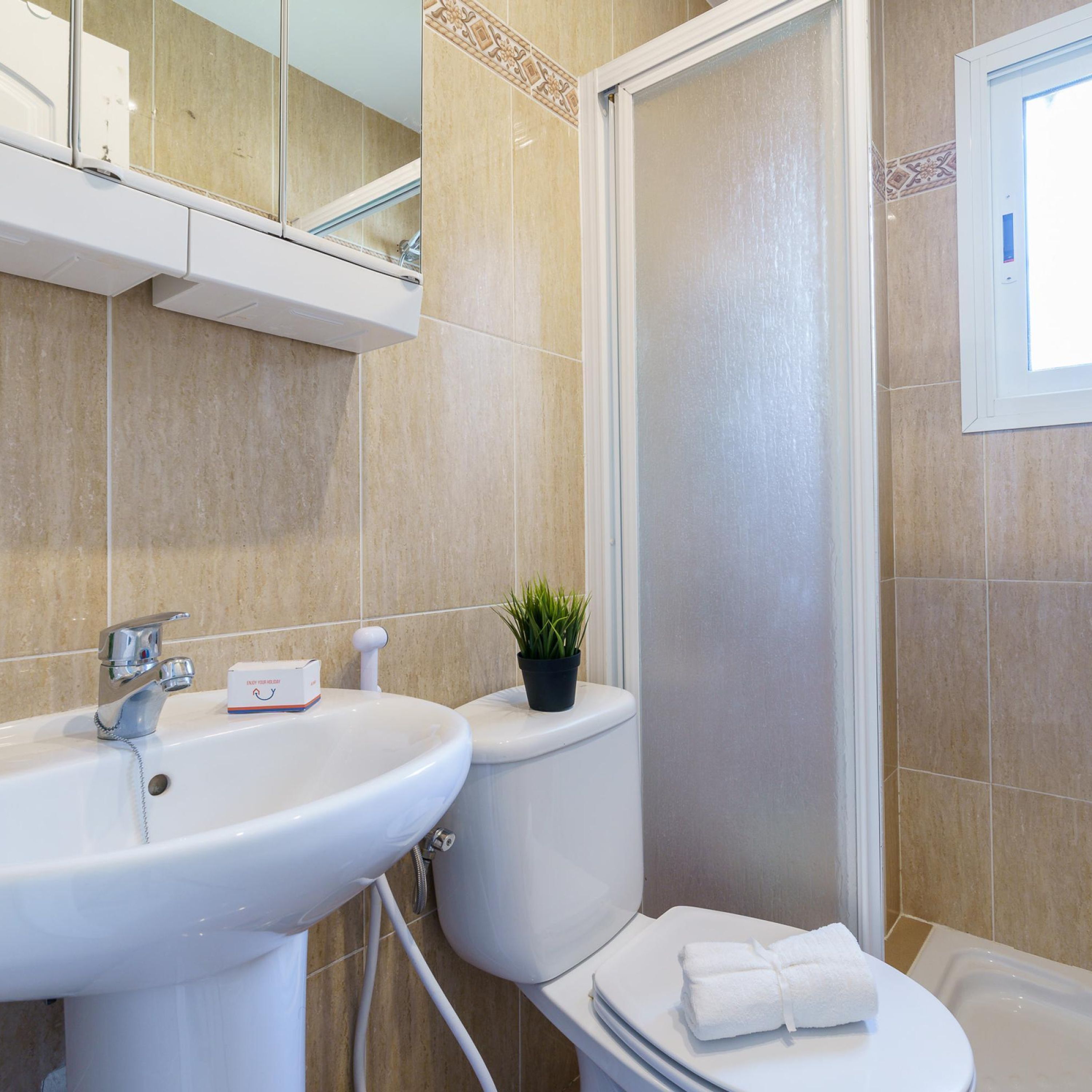 A bathroom with a sink, toilet, and shower.