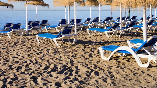 A beach with rows of blue and white sun loungers and straw umbrellas. - Duplex Marbella Concordia Close To Beach (Marbella)