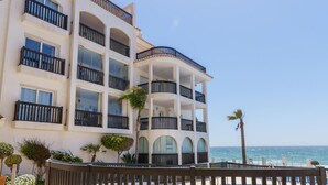 Un hotel a più piani con balconi, piscina e vista sull'oceano.