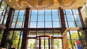A spacious lobby with large windows, a central revolving door, and a distinctive ceiling design. - Shanghai Changxing International Hotel (Shanghai)