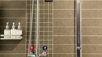 Ein Badezimmer mit Dusche, Ablage für Pflegeprodukte und Temperaturanzeigen.
